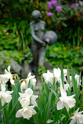 white flowers in the forground with a view of the sculpture in the background