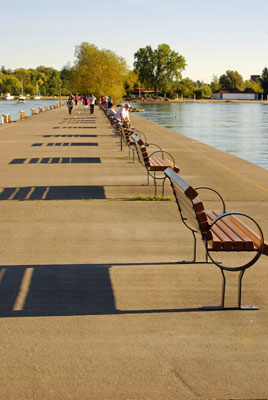 a row of benches cast a pattern of shadows along the pier