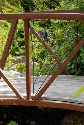metal spider and web decorate a bridge railing