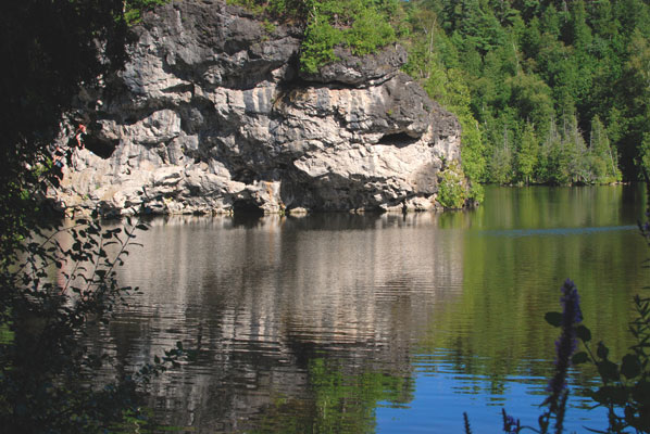 cliffs are reflected in the still water of the lake