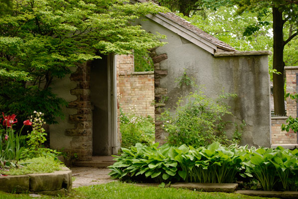 the ruins of an old house with hostas and daylilies in Rosetta McClain Gardens