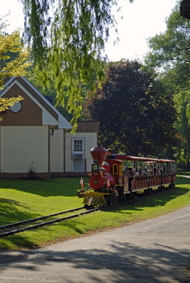 a red train runs along a track in Centreville